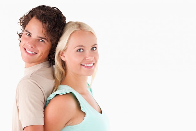 Foto retrato de una pareja de pie espalda con espalda