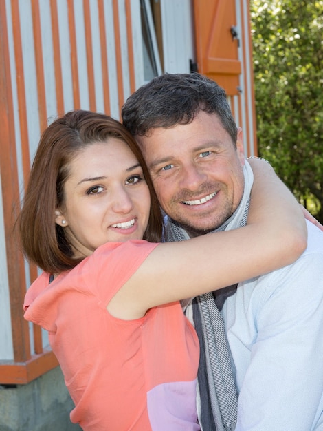 retrato, de, pareja que se abraza, delante de, casa