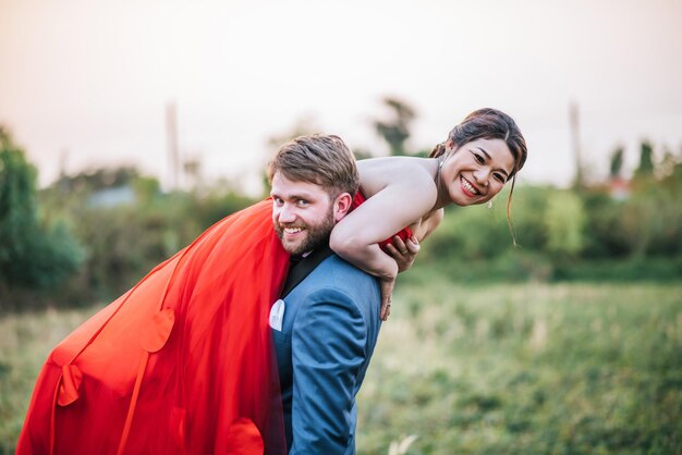 Foto retrato de una pareja de recién casados sonrientes en el campo