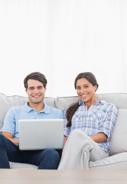 Retrato de una pareja relajante con una computadora portátil