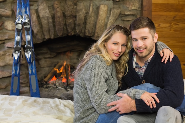 Retrato de una pareja romántica frente a la chimenea encendida