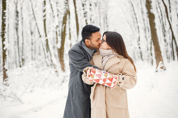 Retrato de una pareja romántica pasando tiempo juntos en el bosque de invierno