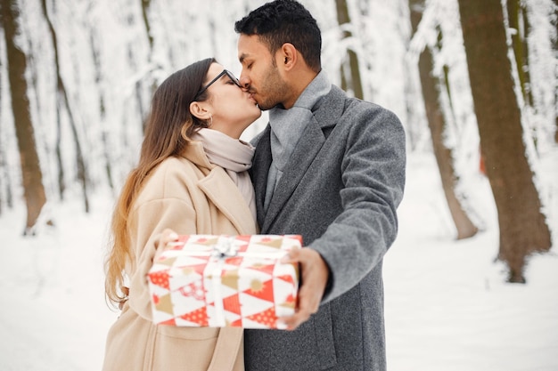 Retrato de una pareja romántica pasando tiempo juntos en el bosque de invierno