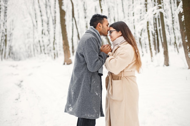 Retrato de una pareja romántica pasando tiempo juntos en el bosque de invierno
