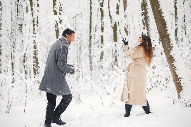 Retrato de una pareja romántica pasando tiempo juntos en el bosque de invierno