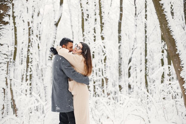 Retrato de una pareja romántica pasando tiempo juntos en el bosque de invierno