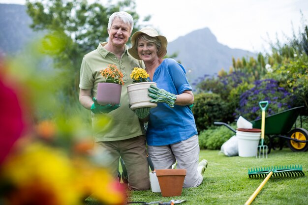 Retrato de pareja senior con plantas en maceta