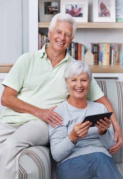 Retrato de pareja senior y sonrisa con sofá de tableta y hogar para aplicación de noticias en línea de redes sociales y libro electrónico Anciano feliz mujer y tecnología digital para sitio web de suscripción y conexión a Internet