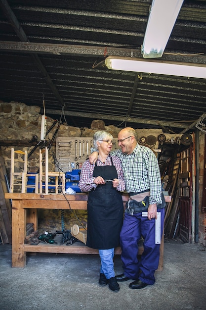 Retrato de pareja senior en un taller de carpintería