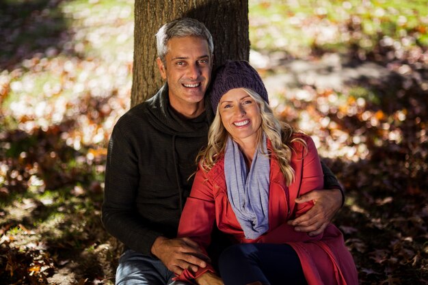 Retrato de pareja sentada bajo un árbol