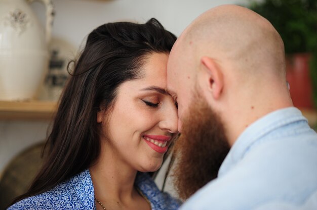 Retrato de pareja sonriendo con sus cabezas juntas.