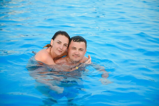 Retrato de una pareja sonriente en una piscina