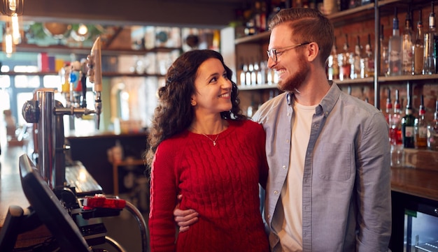 retrato, de, pareja sonriente, poseer, barra, posición, atrás, mostrador