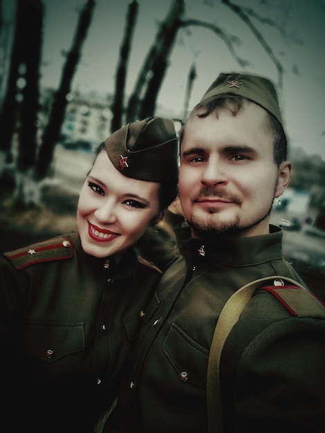 Foto retrato de una pareja sonriente con uniformes