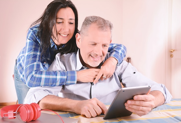 Retrato de pareja usando la computadora portátil en casa