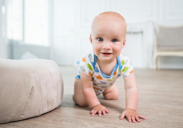 Retrato de un pequeño bebé feliz gateando