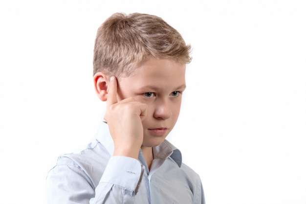 Retrato de un pequeño colegial en una pose pensativa aislado sobre fondo blanco.