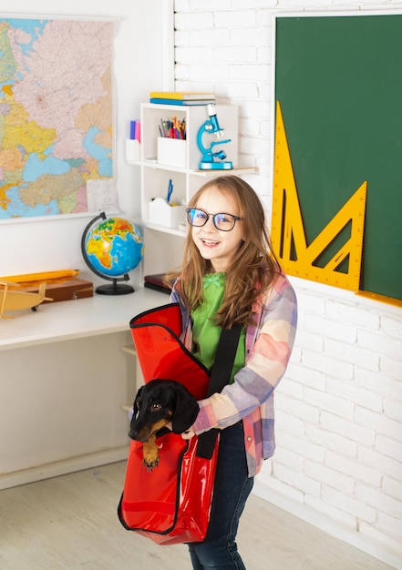 Retrato de un pequeño estudiante jugando con un cachorro Niño en la escuela