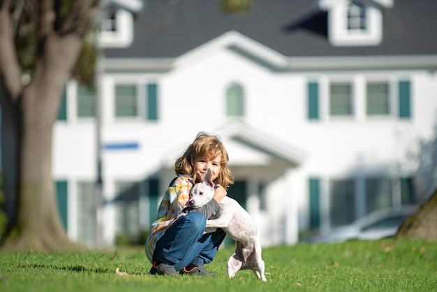 Retrato de un pequeño niño lindo niño con perro relajante en la naturaleza dueño del niño acariciando suavemente a su mascota ...