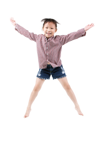 Retrato del pequeño salto asiático feliz del niño aislado en blanco