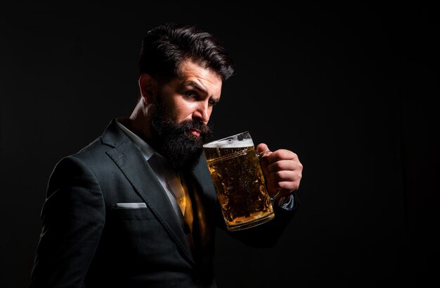 Retrato de perfil de un hombre serio que sostiene una cerveza artesanal aislada en negro