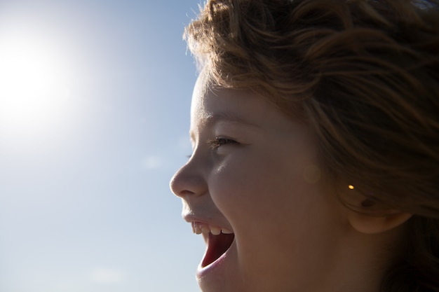 Retrato de perfil de niños, niño feliz gritando. Boca de niños sonrientes.