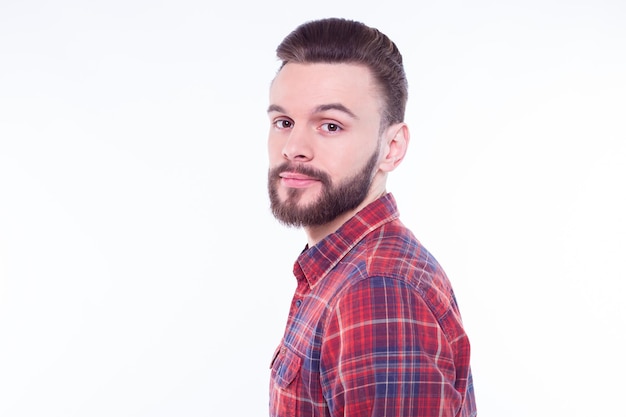 Retrato de perfil o vista lateral de un apuesto joven barbudo con estilo en camisa a cuadros aislado sobre fondo blanco