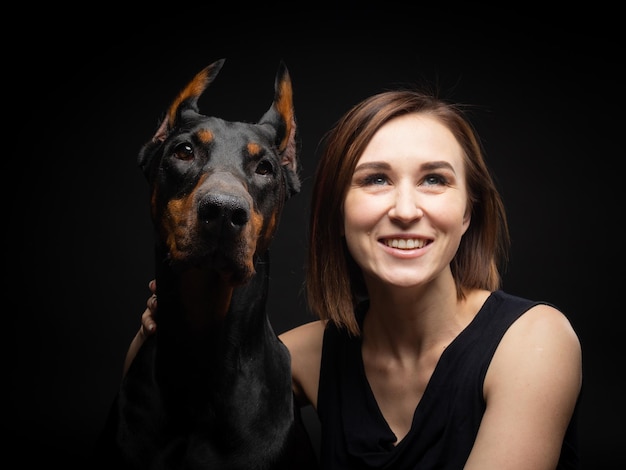 Retrato de un perro Doberman con una chica dueña