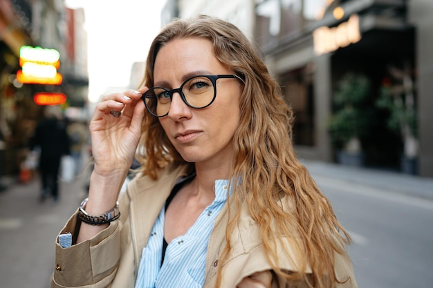 Retrato de una persona de negocios caucásica con anteojos en las calles de la ciudad