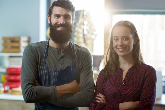 Retrato del personal de panadería sonriente de pie con los brazos cruzados