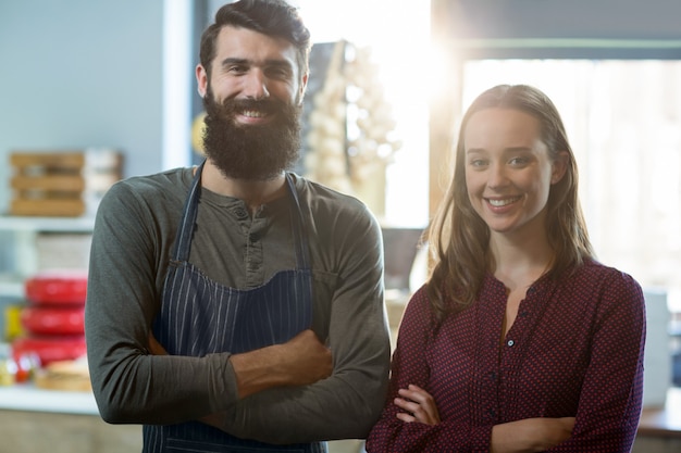 Foto retrato del personal de panadería sonriente de pie con los brazos cruzados