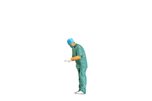 Retrato de personas en miniatura de un joven médico en uniforme aislado sobre un fondo blanco con cl