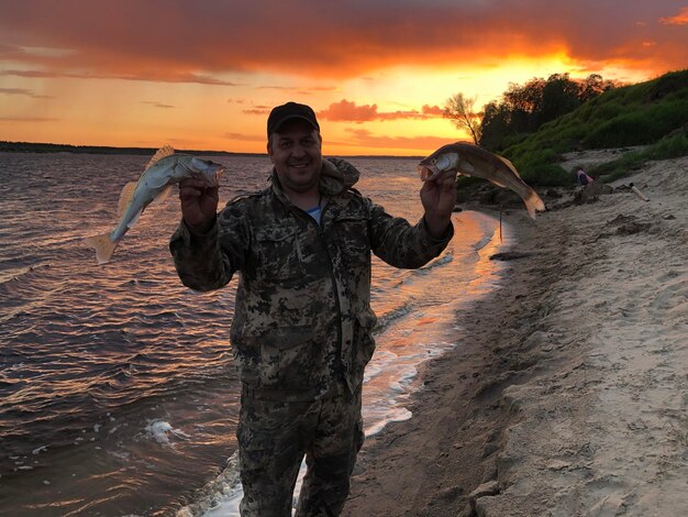 Foto retrato de un pescador con el pescado capturado