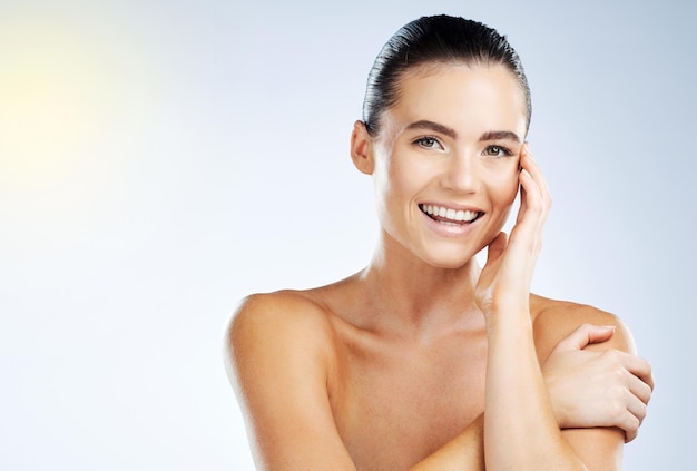 Retrato de piel y belleza de mujer con un brillo facial aislado contra un fondo blanco de estudio Maqueta cosmética y modelo de niña feliz bajo el sol con cara suave natural sonriendo para dermatología