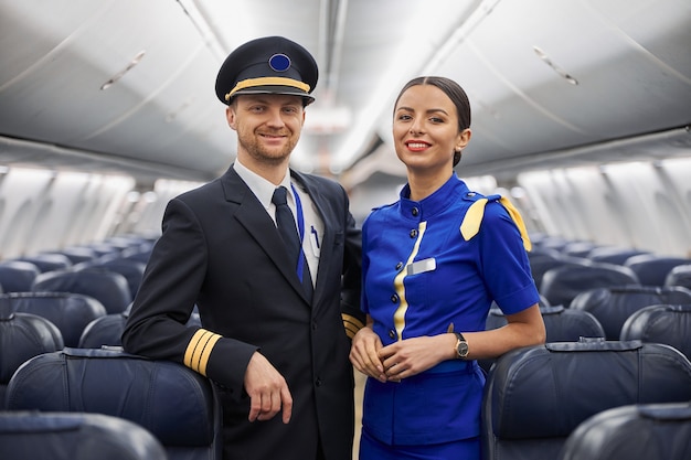 Retrato de piloto y azafata en el salón del avión antes de volar