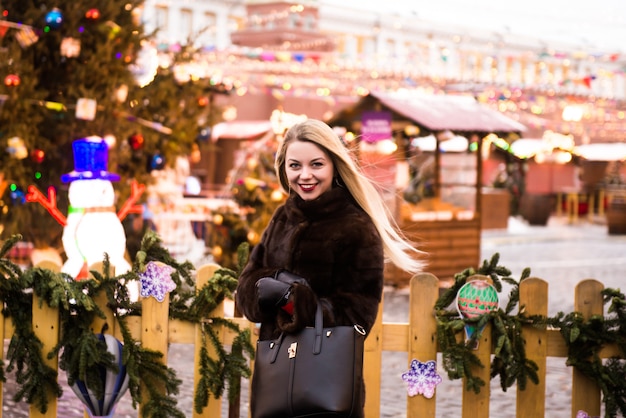 Retrato en pleno crecimiento, hermosa mujer rusa en un abrigo de visón en la Plaza Roja de Moscú en Navidad