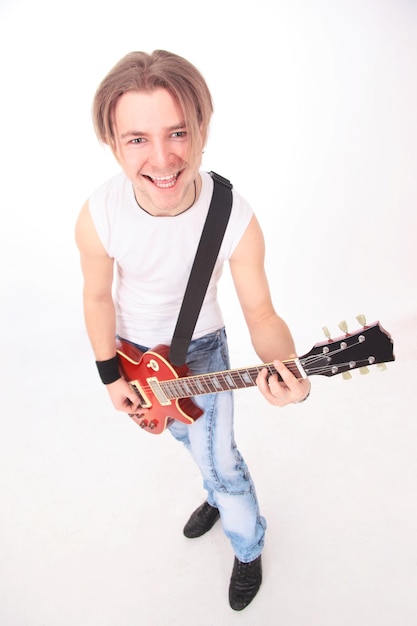 Foto retrato en pleno crecimiento de un joven con guitarra