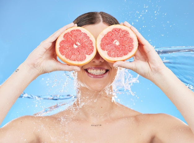 Retrato de pomelo y mujer en el estudio cara salpicadura de agua y promoción del bienestar para la desintoxicación del cuidado de la piel y la ducha Modelo de belleza cubre los ojos con frutas de vitamina c o alimentos saludables en los ojos para la nutrición