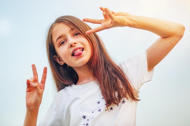 Foto retrato positivo de una adolescente contra el cielo en un día soleado niña de 11 años