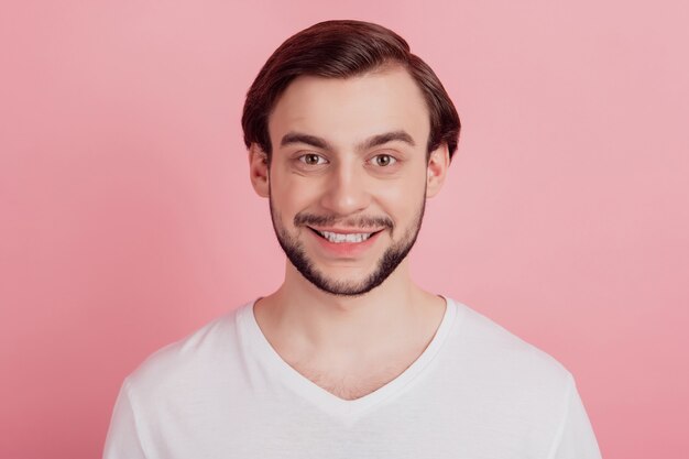 Retrato de positivo alegre chico guapo con dientes sonrisa radiante sobre fondo de color rosa