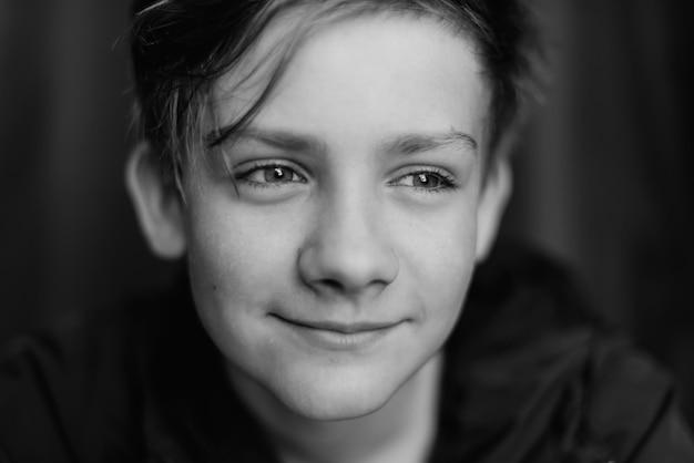 Retrato preto e branco de um adolescente em fundo escuro Foto baixa de um jovem adolescente Fotografia em preto e branco Foco seletivo