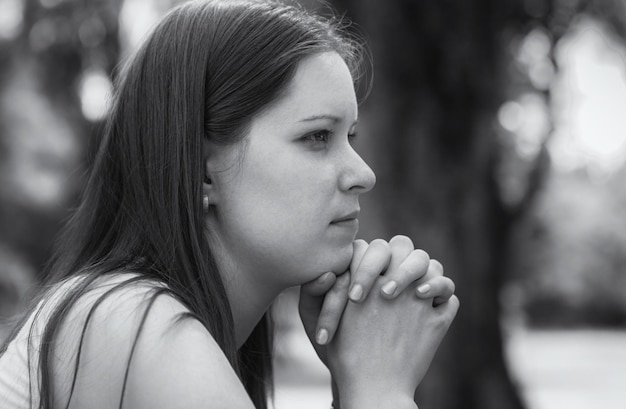 Retrato preto e branco no perfil de uma jovem pensativa, triste e  solitária, fechada, cabeça de pessoa feminina