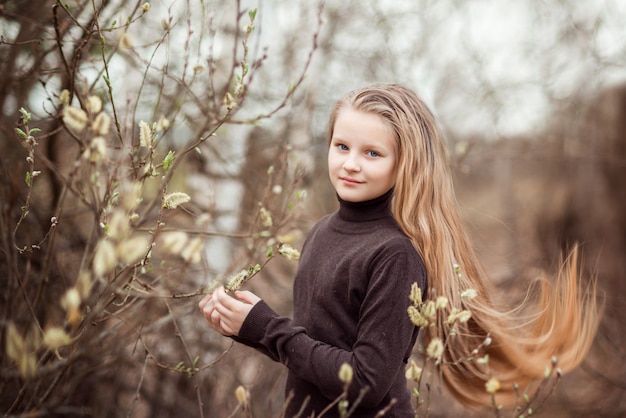 Retrato de primavera de una hermosa niña con un sauce en flor