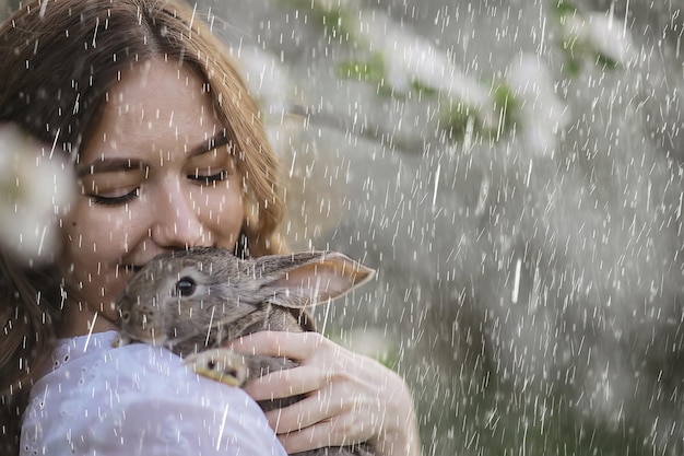 retrato de primavera de niña en un jardín floreciente, felicidad de primavera, tiempo de lluvia en el parque en abril