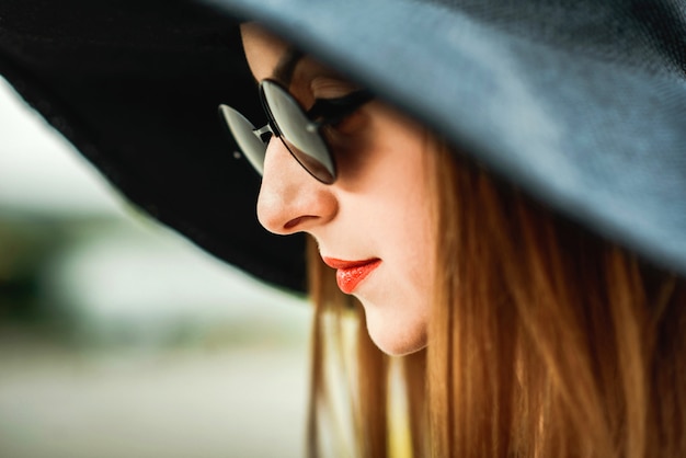 Retrato del primer de la muchacha bonita en sombrero negro