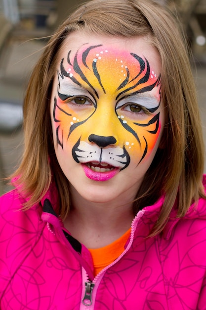 Retrato en primer plano de una adolescente sonriente con la cara pintada en el evento