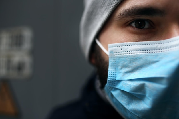 Foto retrato de primer plano al aire libre de un hombre con una máscara médica que está enfermo con una epidemia de virus