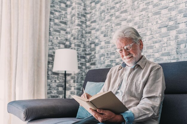 Retrato en primer plano de un anciano feliz y relajado sentado leyendo un libro en casa Hombre maduro