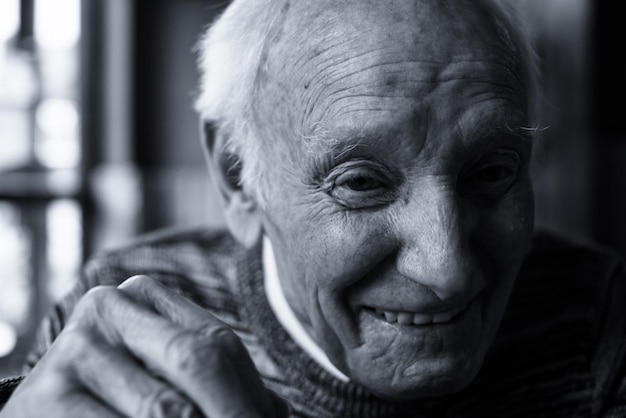 Retrato en primer plano de un anciano sonriente en su casa