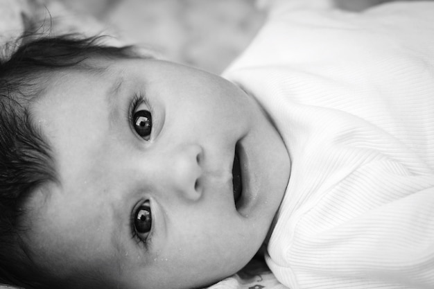 Foto retrato en primer plano de un bebé lindo acostado en la cama